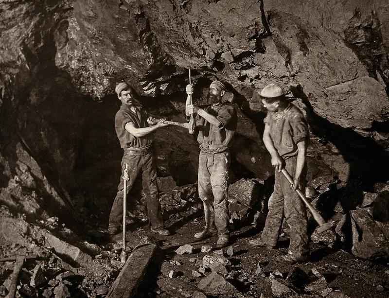 Three miners at work in a shaft of a tin mine at Camborne, Cornwall, photographed by J. C. Burrow