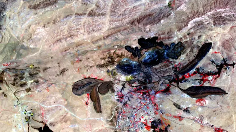 False-colour satellite image of the Bayan Obo mine in Inner Mongolia: dark open pits and tailings ponds in pale desert
