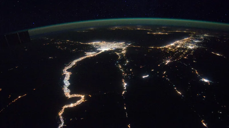 Night view from the International Space Station of the lit-up Nile and its delta, with the Gulf of Suez to the right and the Mediterranean on the horizon