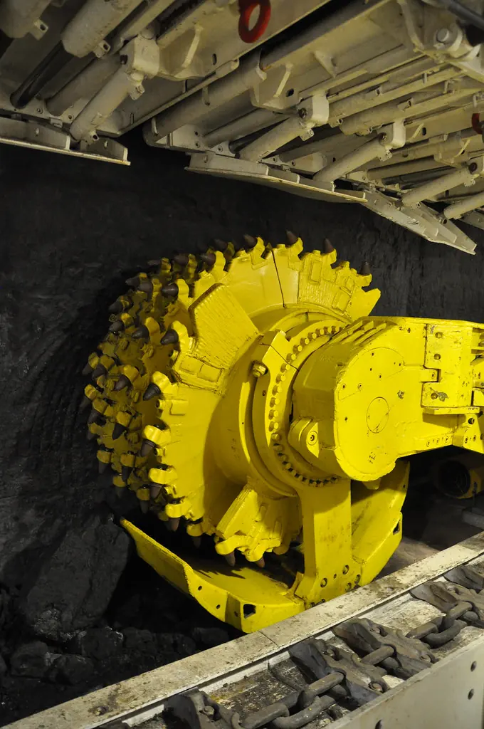 Looking along a longwall face: the shearer drum, the conveyor and the shield canopies overhead