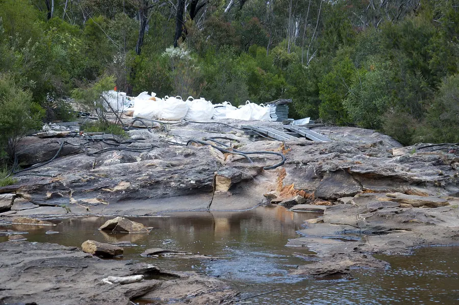 Water flowing over a cracked sandstone rock bar in a bush creek