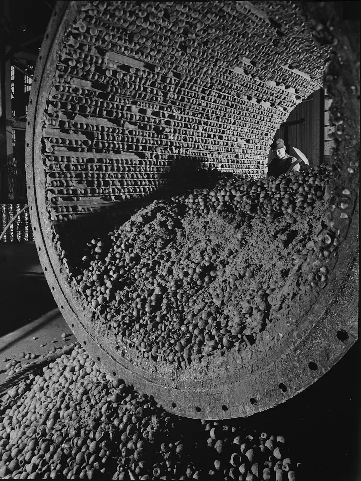 The inside of a ball mill, its ribbed liners and a heap of steel grinding balls