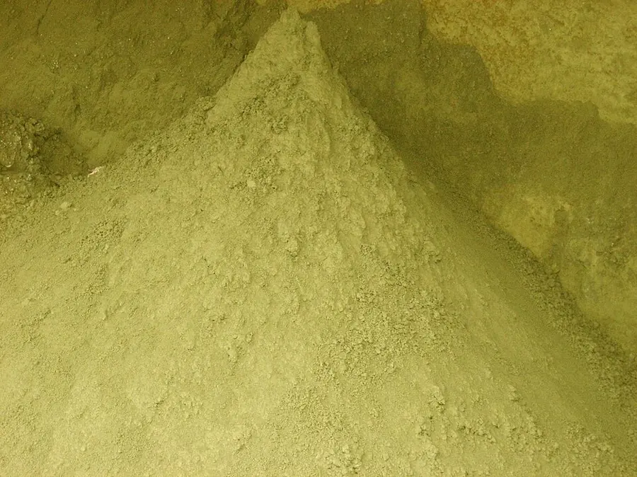 A heap of fine yellow-green copper concentrate powder
