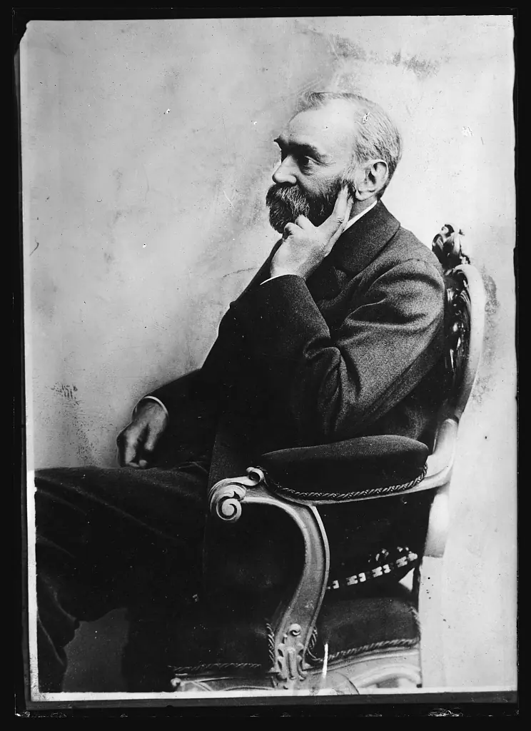 An old photograph of Alfred Nobel, seated, resting his head on one hand
