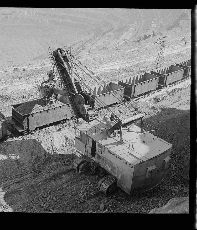 An electric shovel loading copper ore into railway wagons on a bench of the Bingham Canyon pit in 1942
