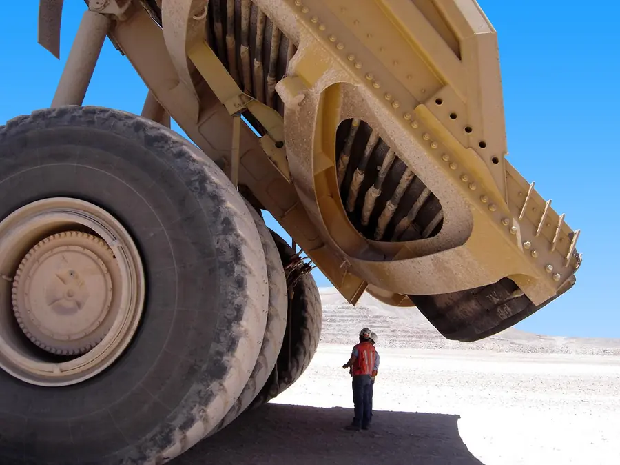 A worker looking up at the raised body of a Cat 797 haul truck at the Escondida copper mine in Chile