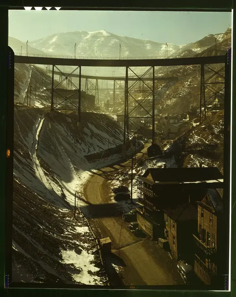 Colour photograph of steel trestles crossing a snowy canyon with mountains behind