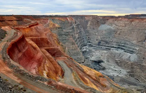 Terraced red and grey walls of a deep open pit